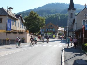 Cyclists riding through a village with a church