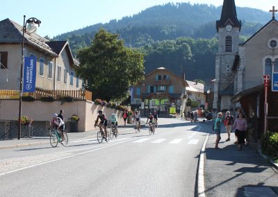 Cyclists riding through a village with a church